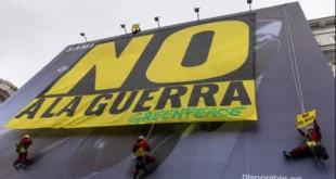 Activistas pacifistas y ambientalistas despliegan, sobre un gran aviso comercial, una pancarta en rechazo a la guerra contra Irán, el pasado marzo en Madrid. Además del costo en vidas y en personas heridas y desplazadas, el conflicto que ya lleva seis meses causa enormes daños materiales, impactos negativos en la economía global, incremento del gasto militar y daños ambientales. Imagen: Greenpeace